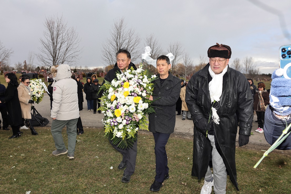 A group of people walking with flowers

Description automatically generated